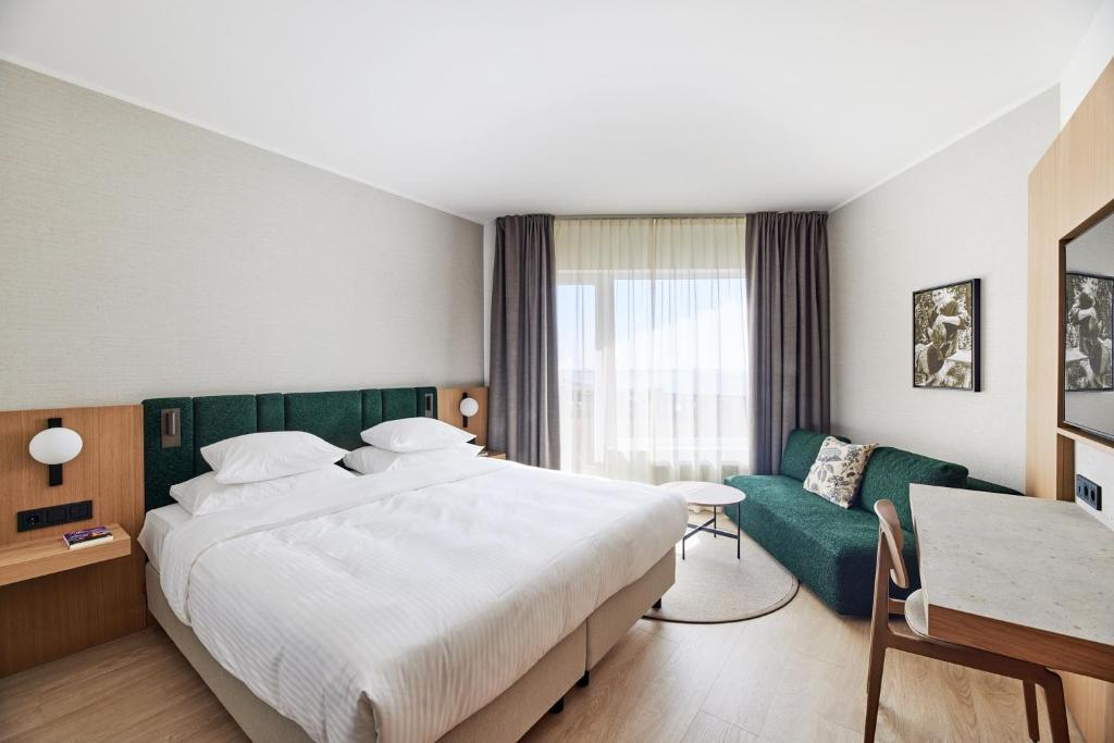 库雷萨雷乔治奥特斯温泉酒店的酒店客房设有一张大床和一张沙发。