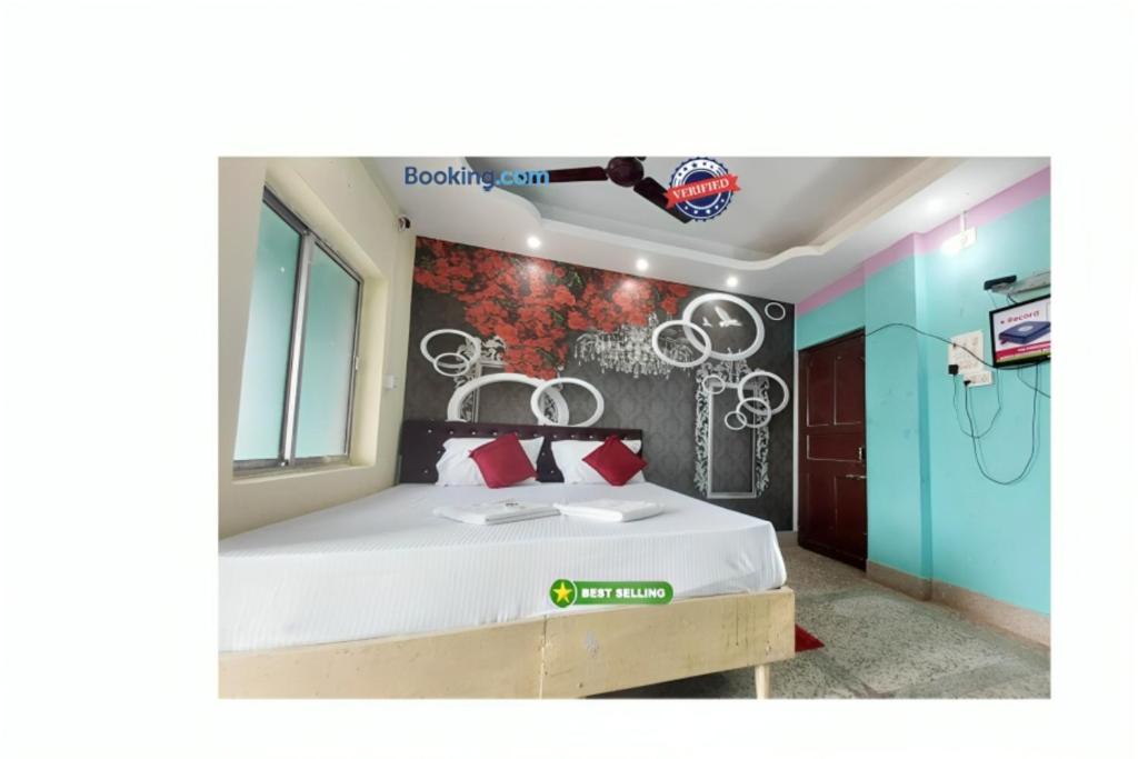 普里Hotel J K Inn Puri Near Sea Beach的一间卧室配有一张床,墙上挂着绘画。