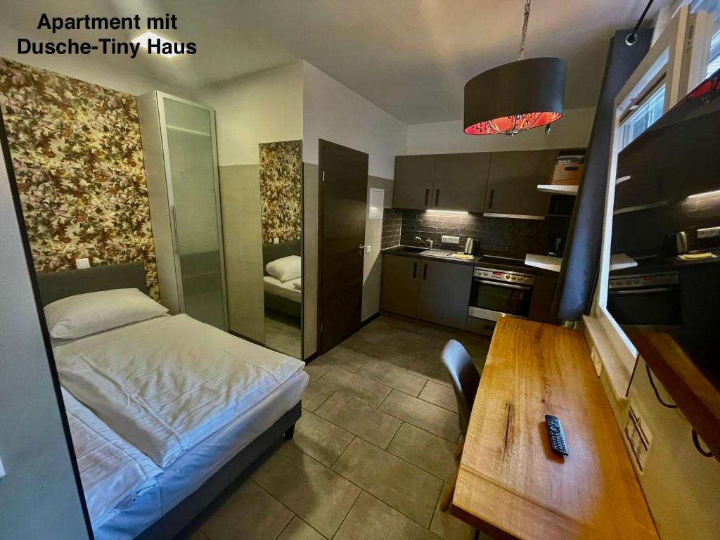 黑尔福德KobyApartment TinyHaus的一间带床和木桌的小卧室