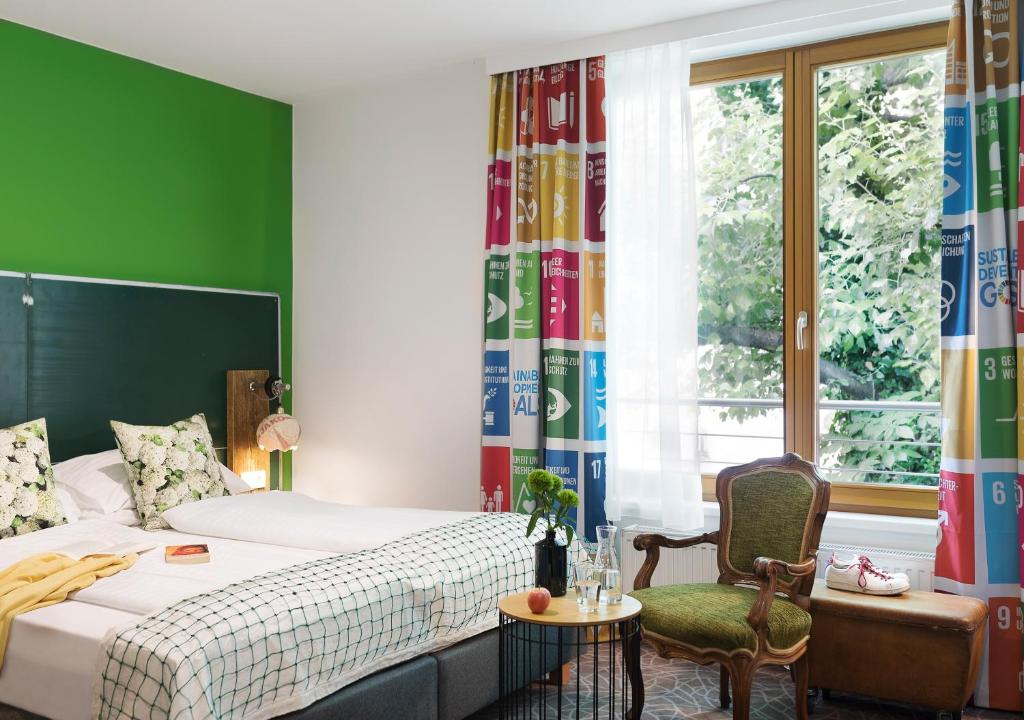 维也纳斯塔德尔精品酒店的卧室配有床、椅子和窗户。