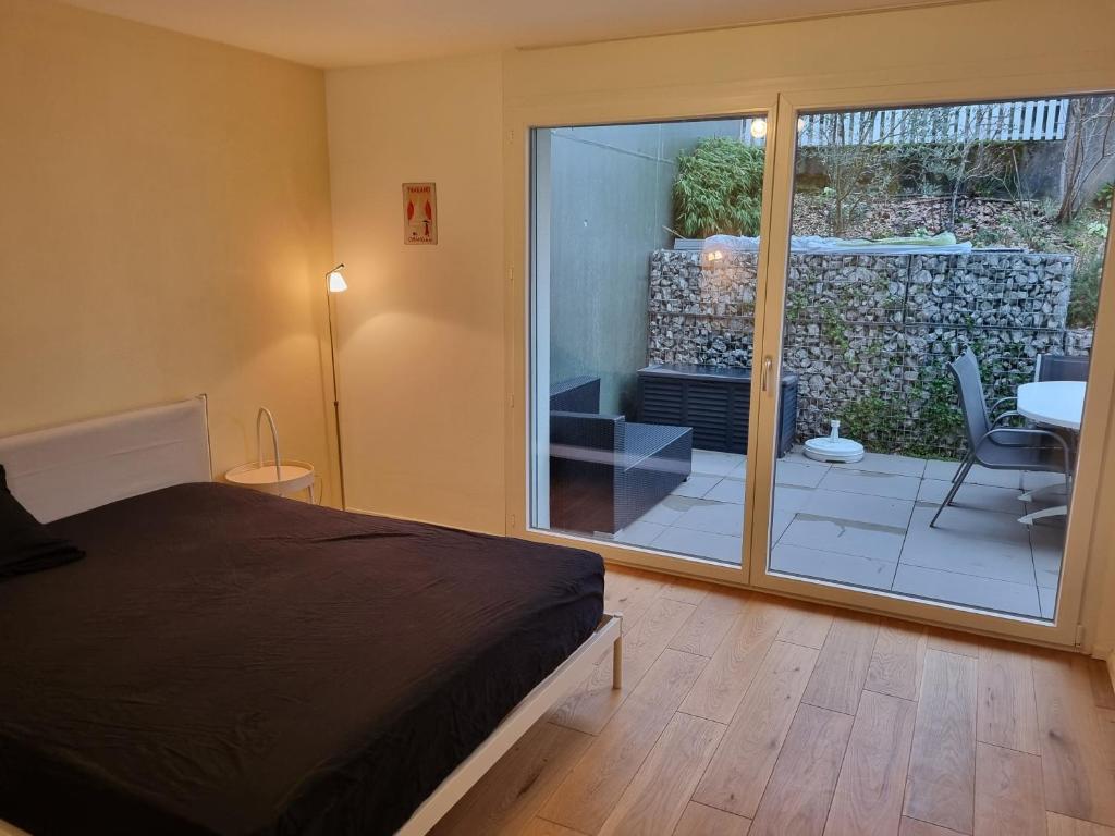 穆尔滕Elegant Suites Murten的一间卧室设有一张床和一个滑动玻璃门