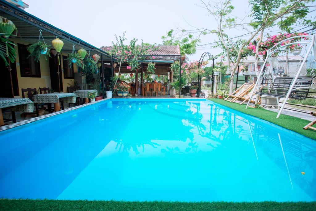 峰牙Phong Nha Ecolodge的一座房子前面的蓝色海水大型游泳池