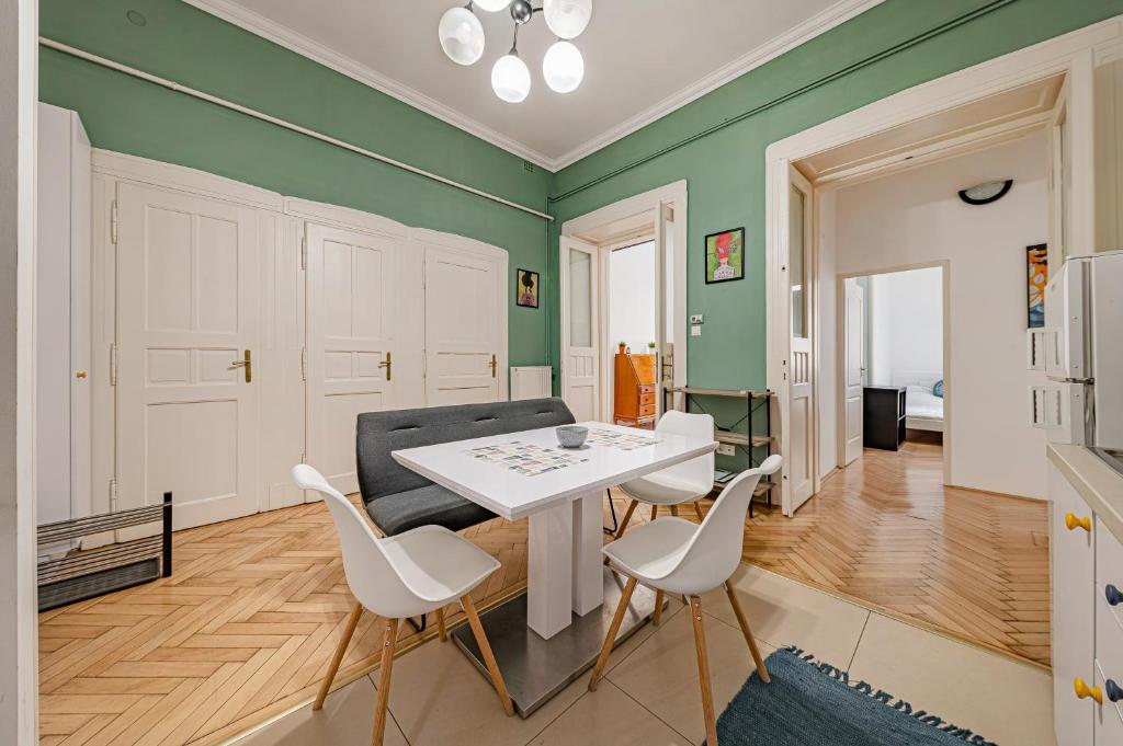 布达佩斯Downtown Rooms Wesselenyi的客厅设有绿色的墙壁和白色的桌椅
