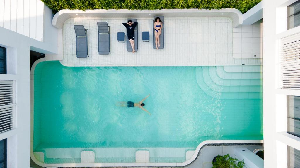 曼谷Saan Hotel Sathorn的游泳池的顶部景色,其中有2人