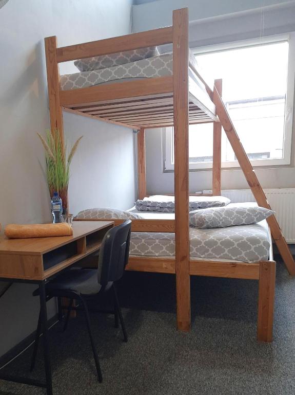 罗兹GO Hostel Rewolucji的一间卧室配有一张桌子和一张双层床。