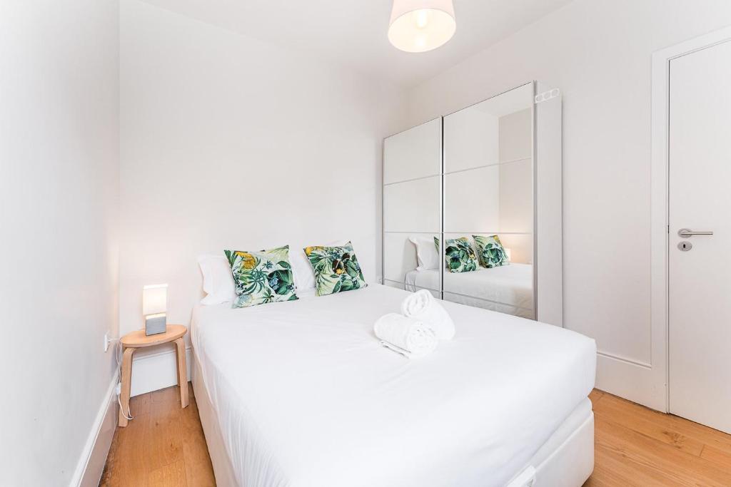 波尔图GuestReady - Camões Refuge的白色卧室配有床和镜子