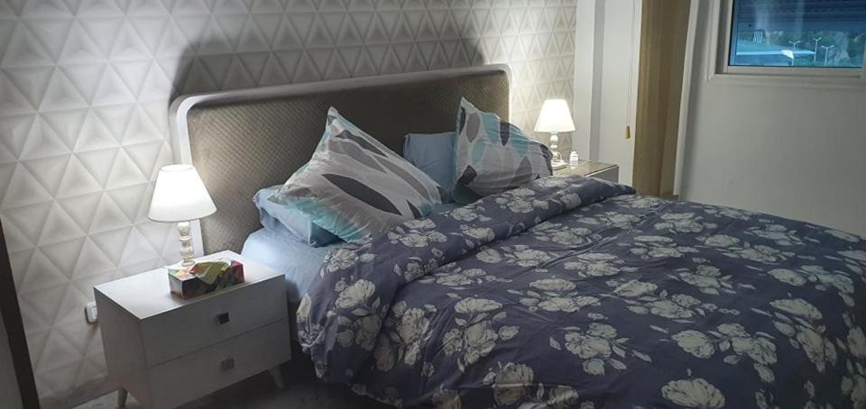 拉古莱特LUX & VIP apartment at Berges du Lac 2 Tunis的一间卧室配有一张带蓝色棉被和枕头的床