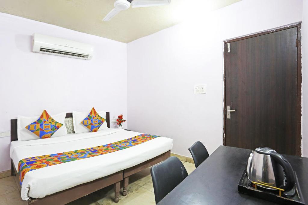 新德里Twamev Punjabi Bagh的一间卧室配有一张床和一张桌子及椅子