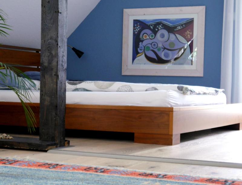 伍珀塔尔ZwischenRaum的蓝色墙壁的客房内的一张木床