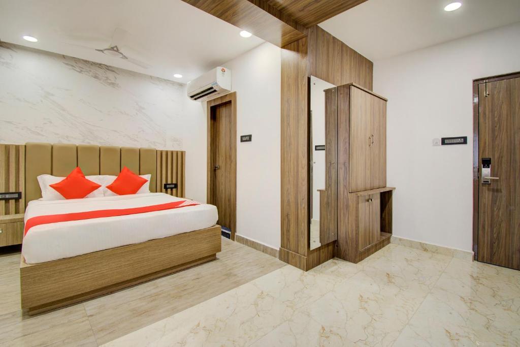 维杰亚瓦达V Hotel的一间卧室配有一张带红色枕头的床