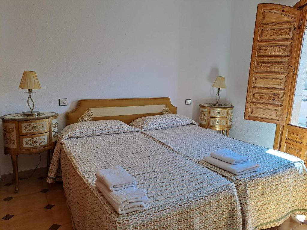 OsmaWAXSIMA Burgo de Osma的一间卧室配有一张床,上面有两条毛巾