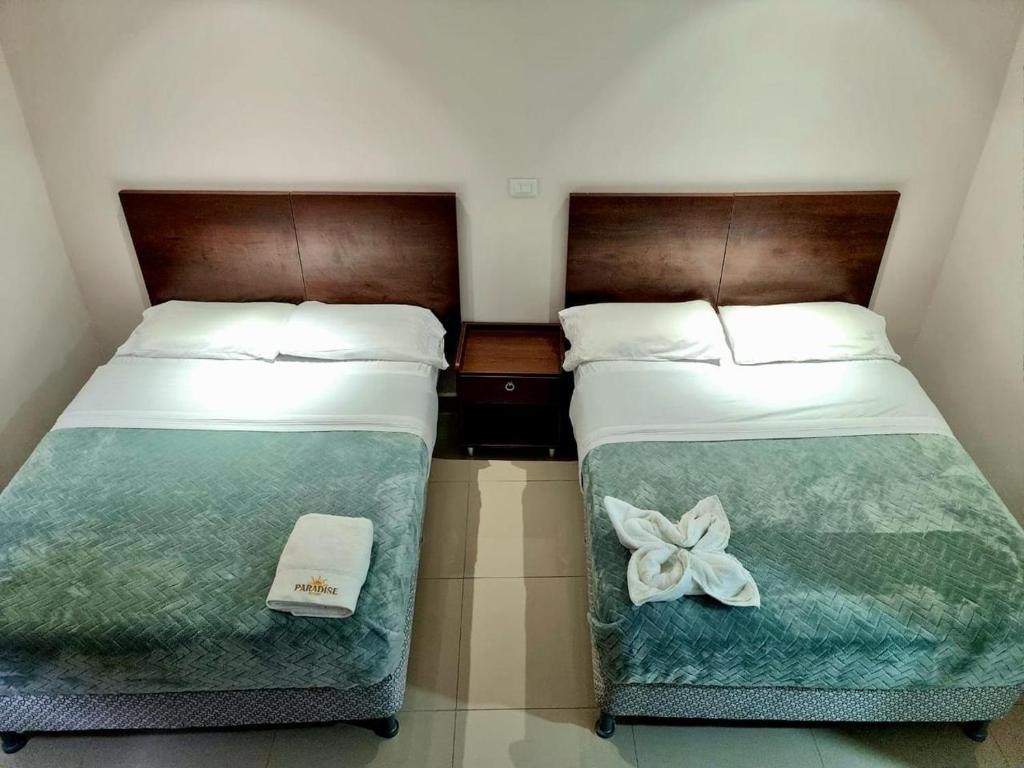 Los SantosParadise Resort的两张睡床彼此相邻,位于一个房间里