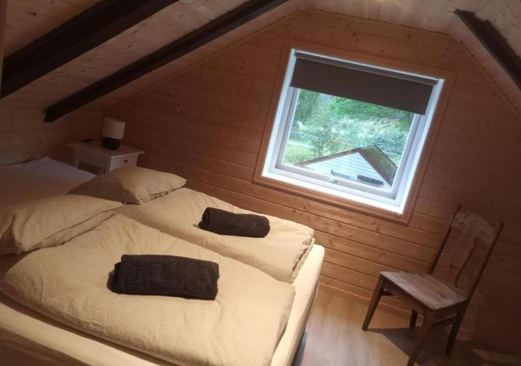 艾菲约德An authentic experience in picturesque Eidfjord的一间卧室配有一张带窗户和椅子的床