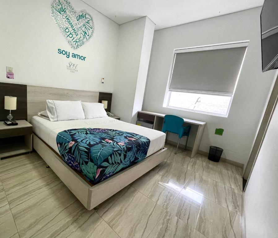 麦德林Hotel Sixtina Plaza Medellin的一间卧室配有一张床、一张书桌和一个窗户。