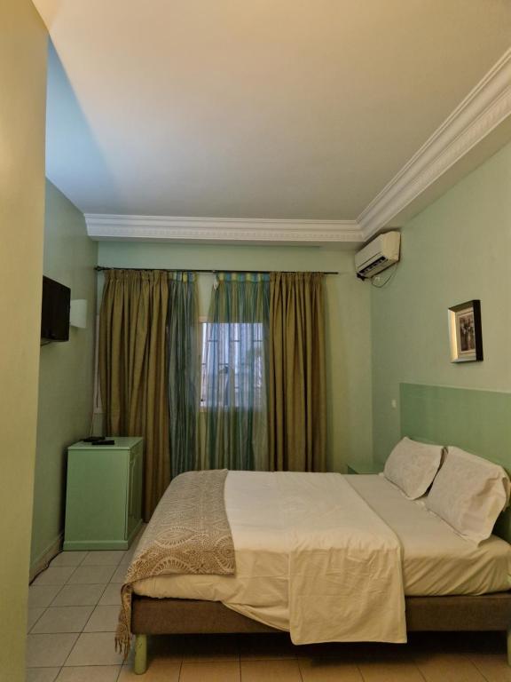 利伯维尔Association LES PYRAMIDES GABON的一间卧室设有一张大床和一个窗户。