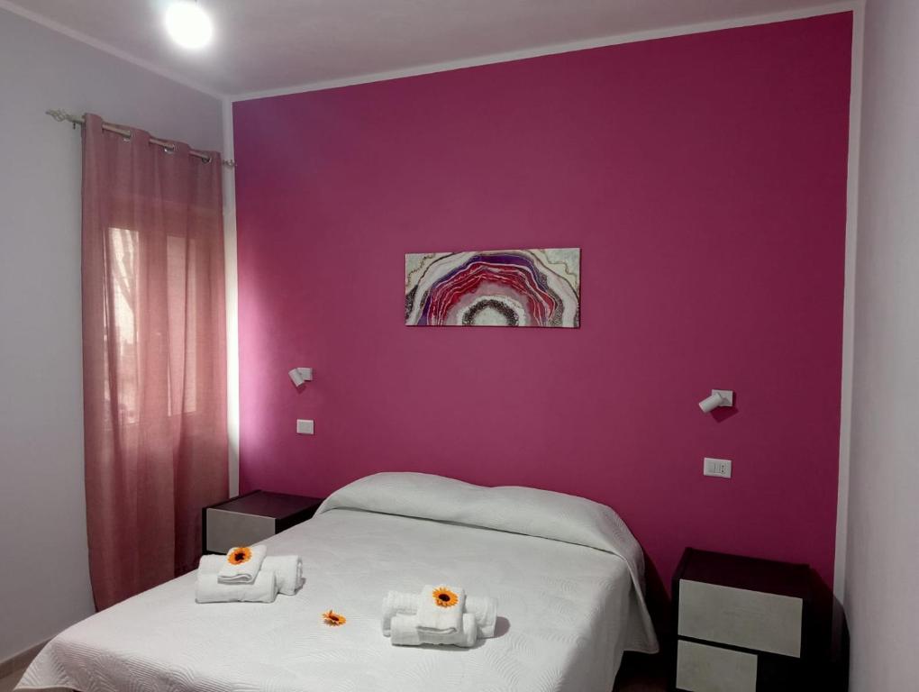 多尔加利CASA DEL CORSO的一间带紫色墙壁的卧室和两张带毛巾的床
