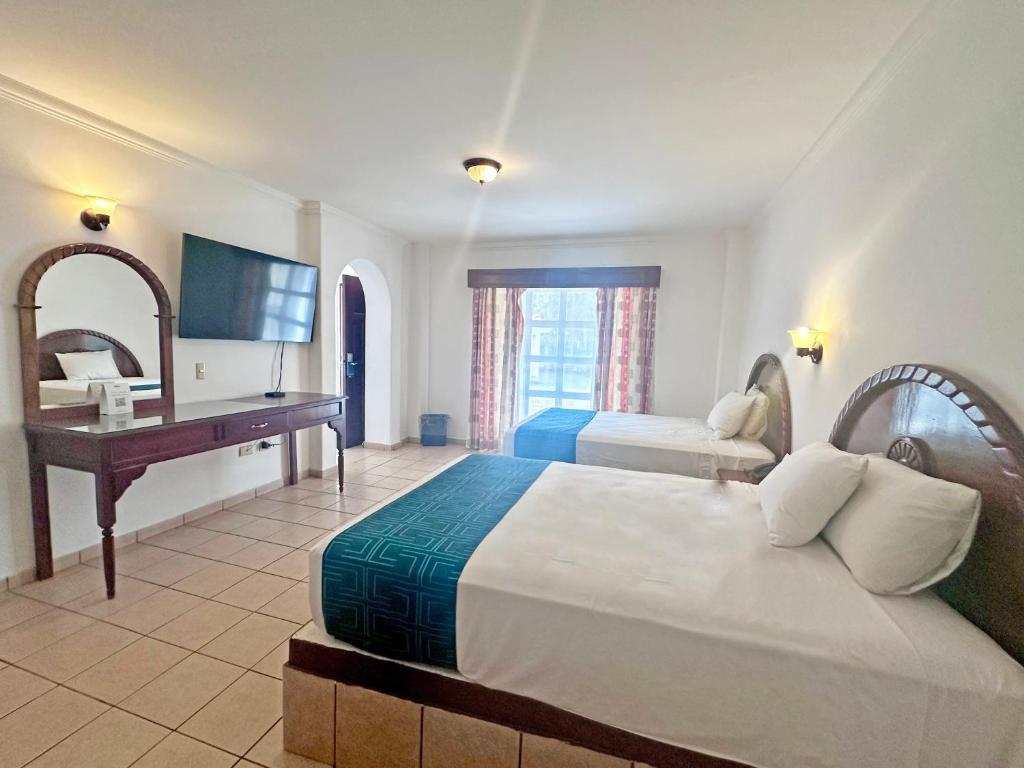库利亚坎InHouse Select Hacienda Tres Rios的酒店客房配有两张床和一张书桌