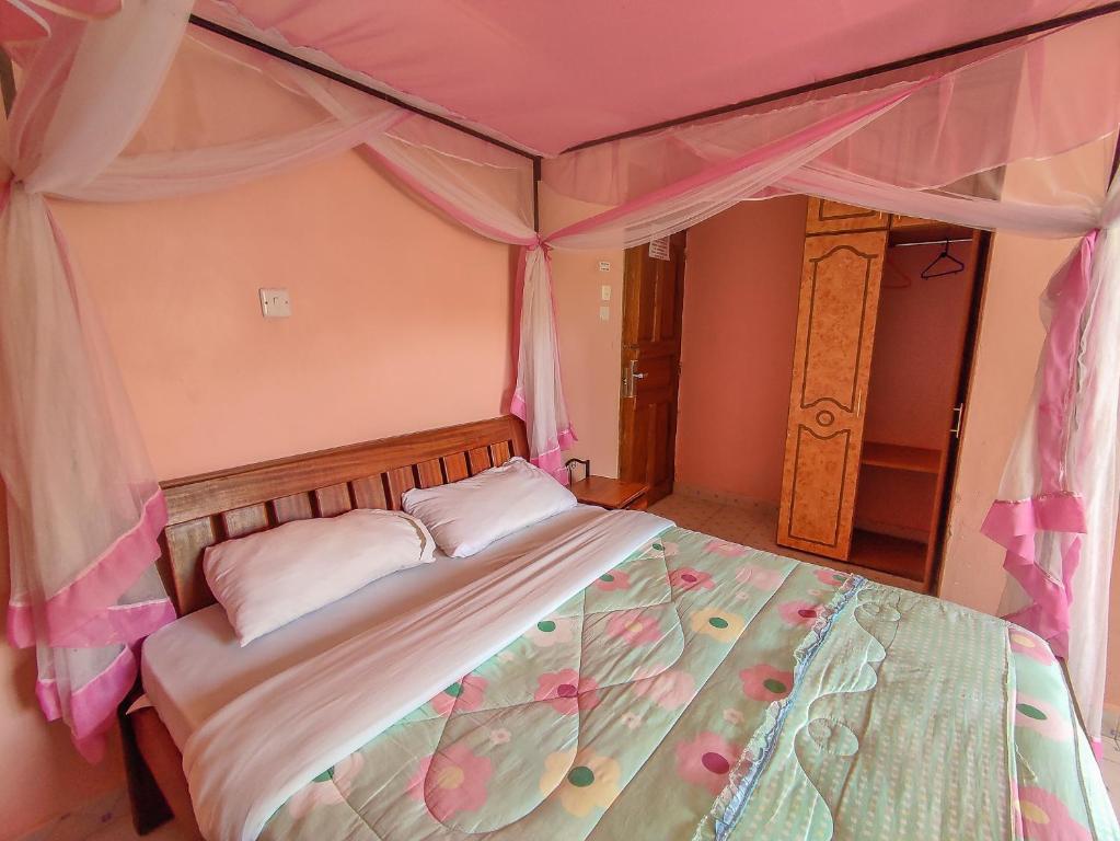 Sunciti Resort Sagana的一间卧室配有带鲜花的天蓬床