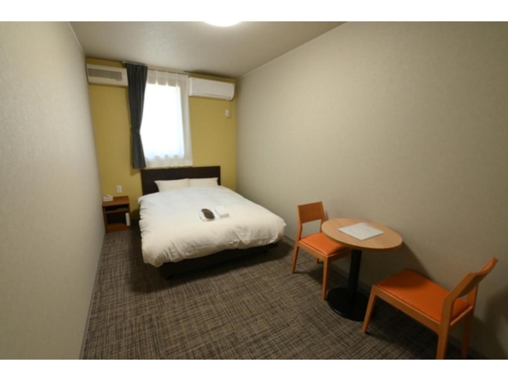 OnagawaＳｗｉｍｍｙ Ｉｎｎ Ｏｎａｇａｗａ - Vacation STAY 56625v的卧室配有一张床和一张桌子及椅子