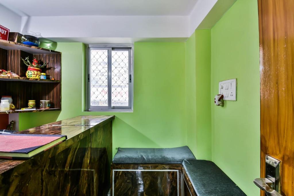 DānāpurOYO RP Palace Inn的绿色的厨房,配有长凳和窗户