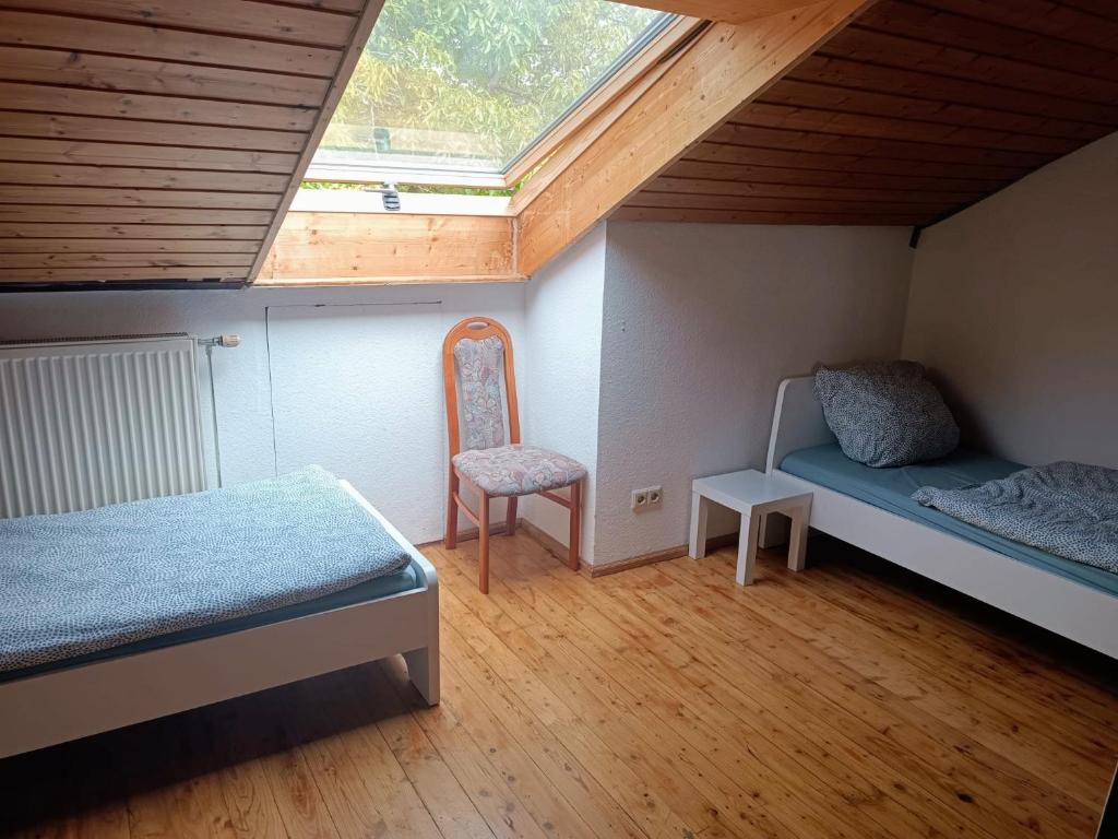 雷宁根L8 Street Apartments - Renningen的小房间设有两张床和椅子
