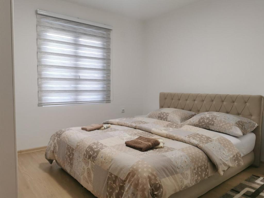 维舍格勒Apartman Mani的一间卧室配有带两个枕头的床和窗户