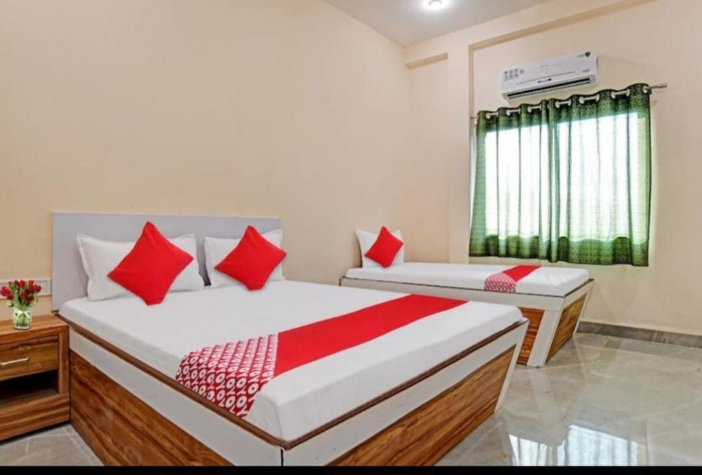 印多尔Paradise Inn的一间卧室配有两张带红色枕头的床