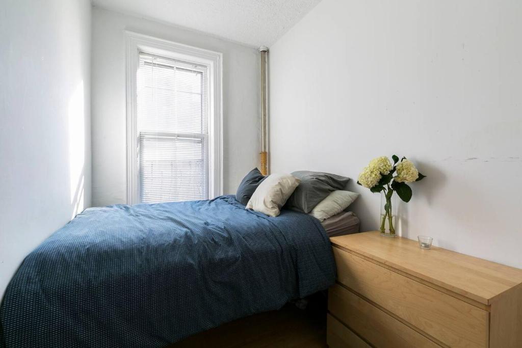 纽约Sundrenched East Village Apartment的一间卧室,配有一张床和花瓶