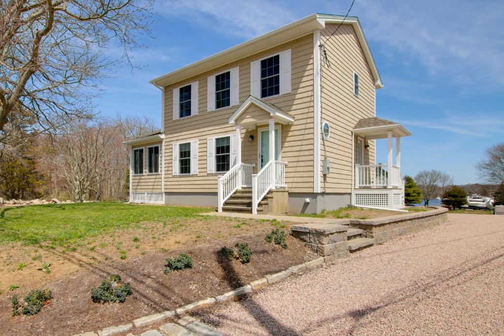 PawcatuckCharming Home with Yard Steps to Pawcatuck River!的黄色的房子,设有门廊和车道