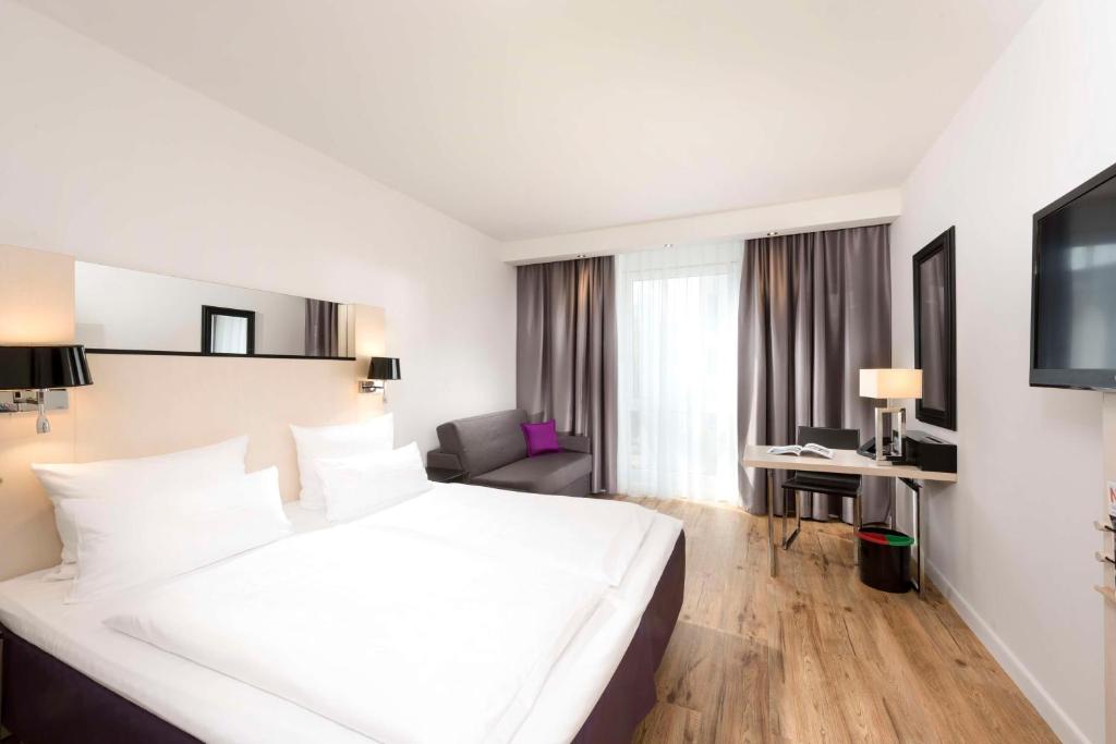 柏林库尔菲尔斯滕斯堪柏林酒店的酒店客房设有一张白色大床和一张书桌