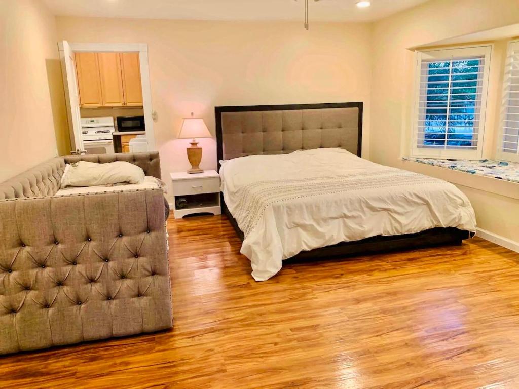 奥欣赛德Spacious & Pet Friendly Oceanside Home的一间卧室配有一张床和一张沙发,铺有木地板