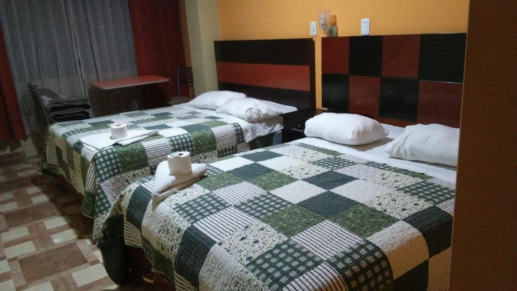 万卡约HOTEL MAJHAMI的两张位于酒店客房的床铺,配有一张 ⁇ 面毯