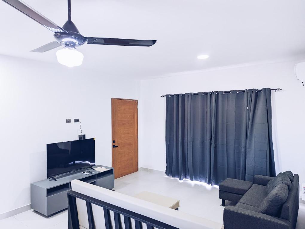 圣斐利-银港Apartment in Sosua - 4 Minutes From The Airport的客厅配有吊扇和电视。