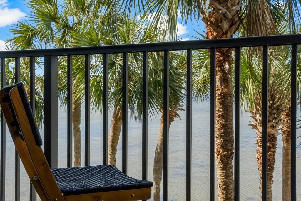 德斯坦Sandestin Bayfront Studio with balcony and breathtaking views的棕榈树和海滩阳台的椅子