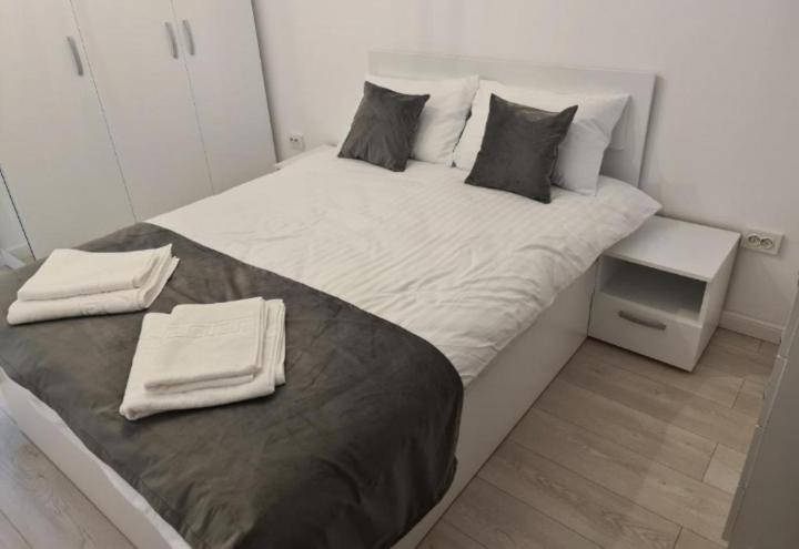 巴克乌Apartament de lux Bacău的一张大白色的床,里面装有毛巾