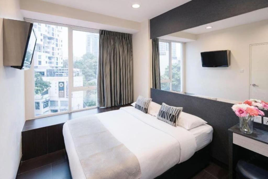 新加坡Value Hotel Nice的一间卧室设有一张大床和一个大窗户