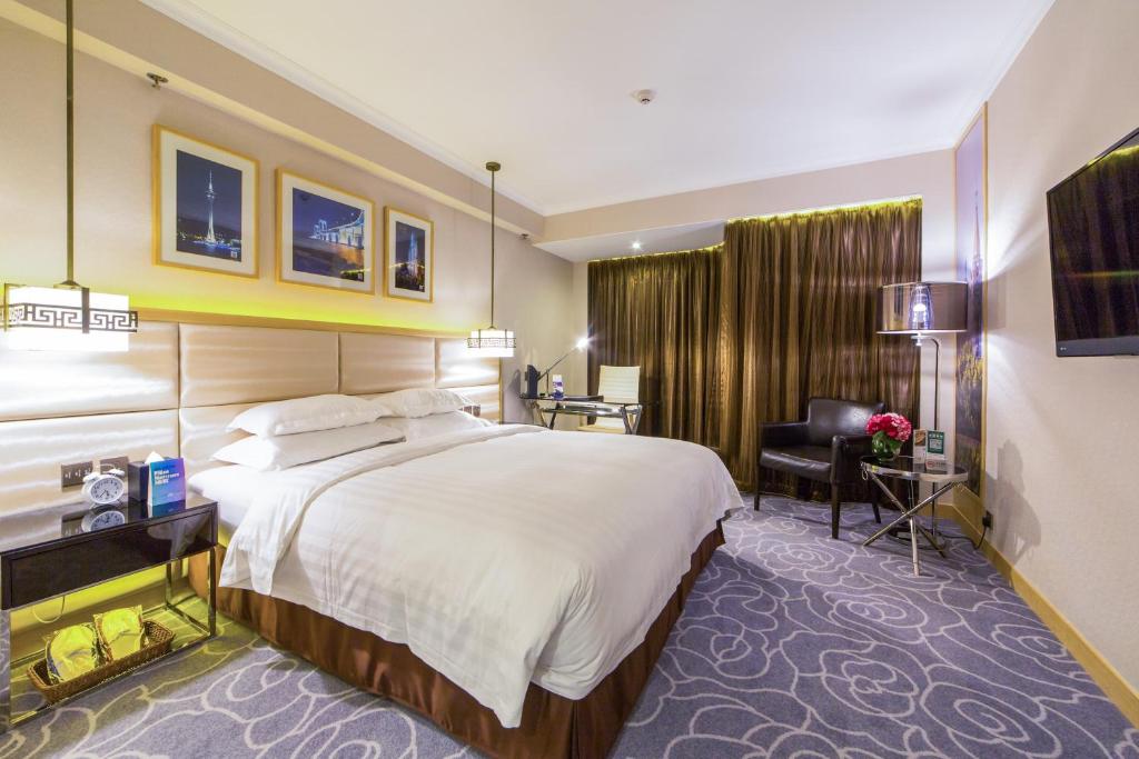 澳门Metropark Hotel Macau的酒店客房设有一张大床和一张书桌。
