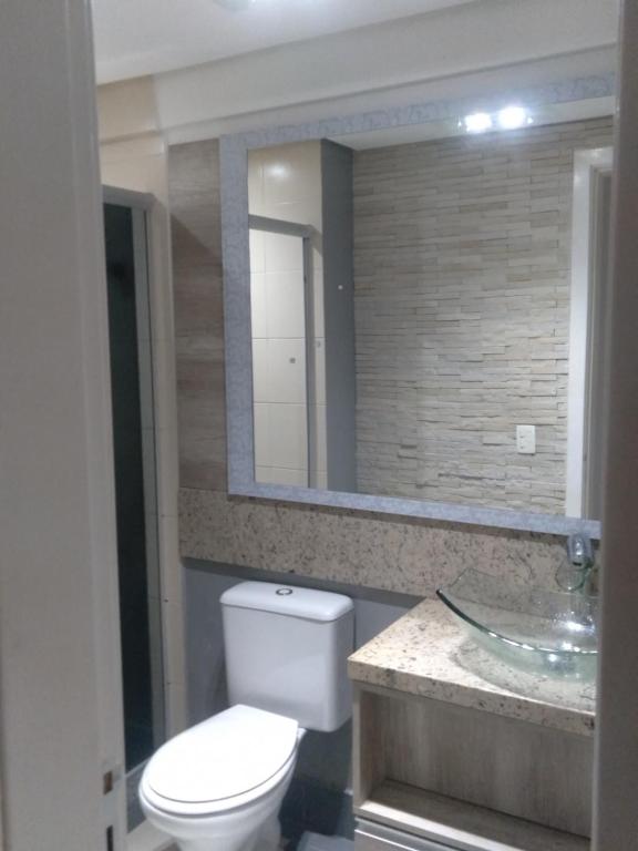 南卡希亚斯Apartamento na Serra Gaúcha的一间带卫生间、水槽和镜子的浴室