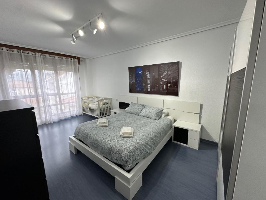 萨龙El pisuco的一间白色卧室,配有床和电视