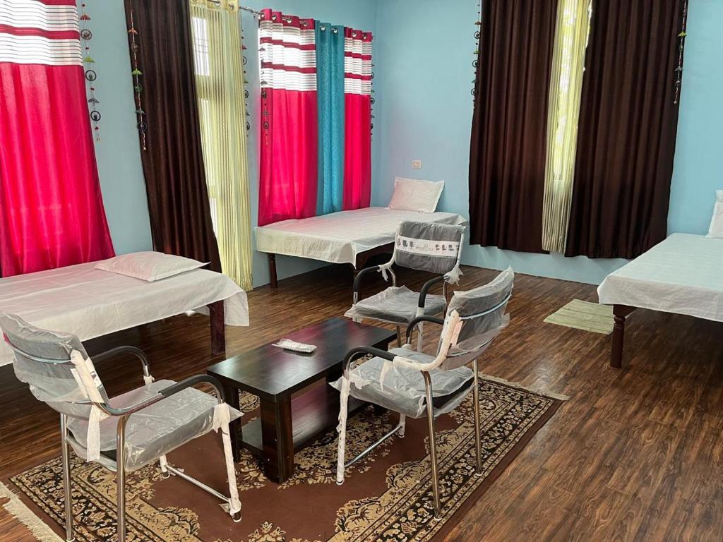 AyodhyaShri SeetaRam Home Stay Near Shri Ram Janmabhoomi Mandir Ayodhya的一间设有两张床、椅子和一张桌子的房间