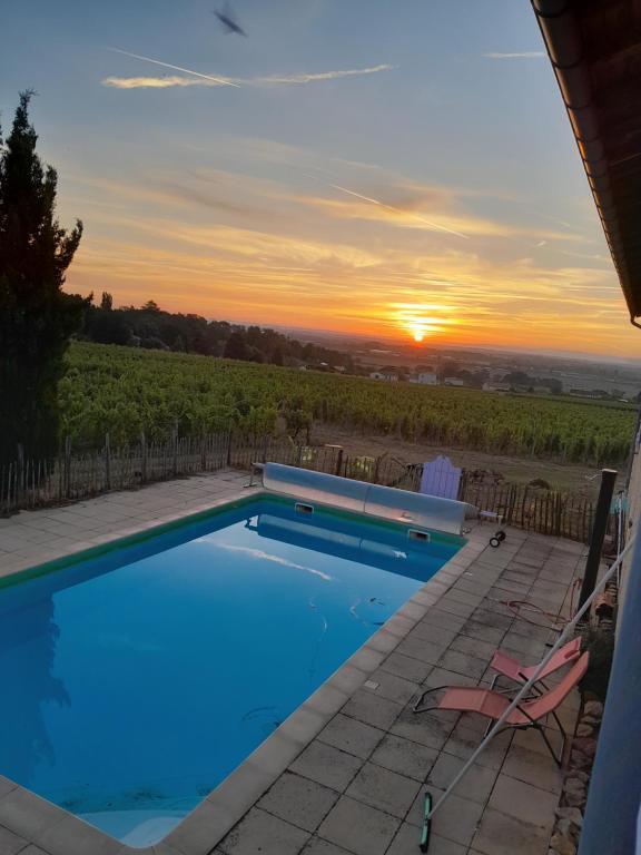 VinzellesLa côte des Blancs - Domaine viticole & maison d'hôtes的一座享有日落美景的游泳池