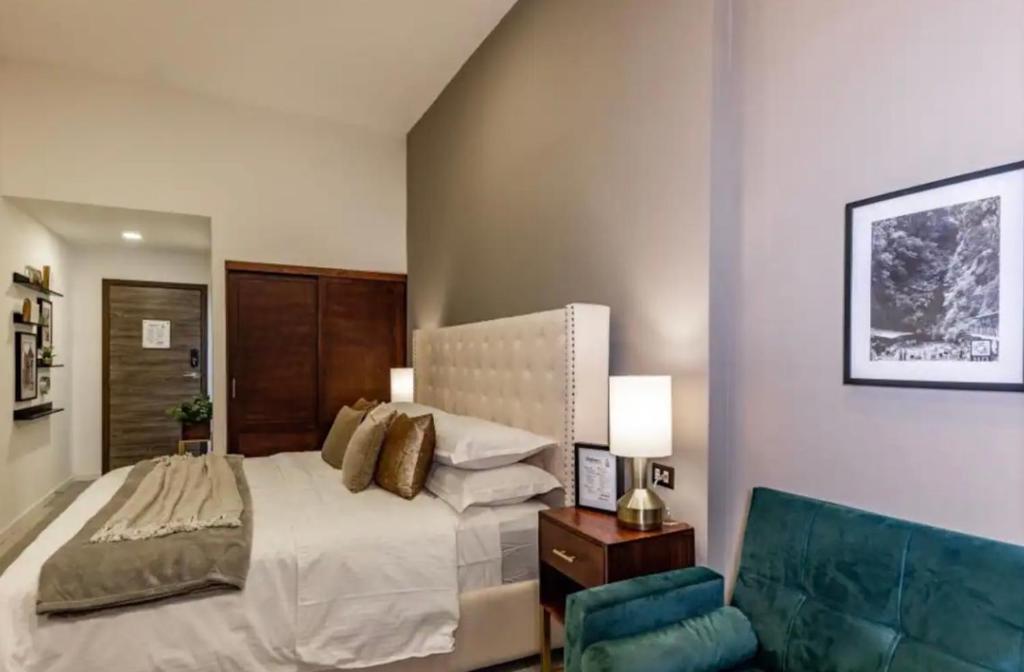克萨尔特南戈Central Park Jr. Suites的一间卧室配有一张大床和一张蓝色椅子