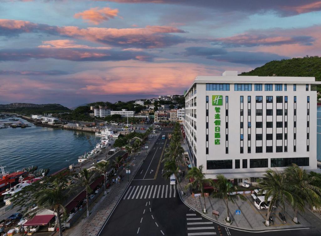 珠海珠海桂山岛智选假日酒店的一座白色的大建筑,上面有绿色的标志
