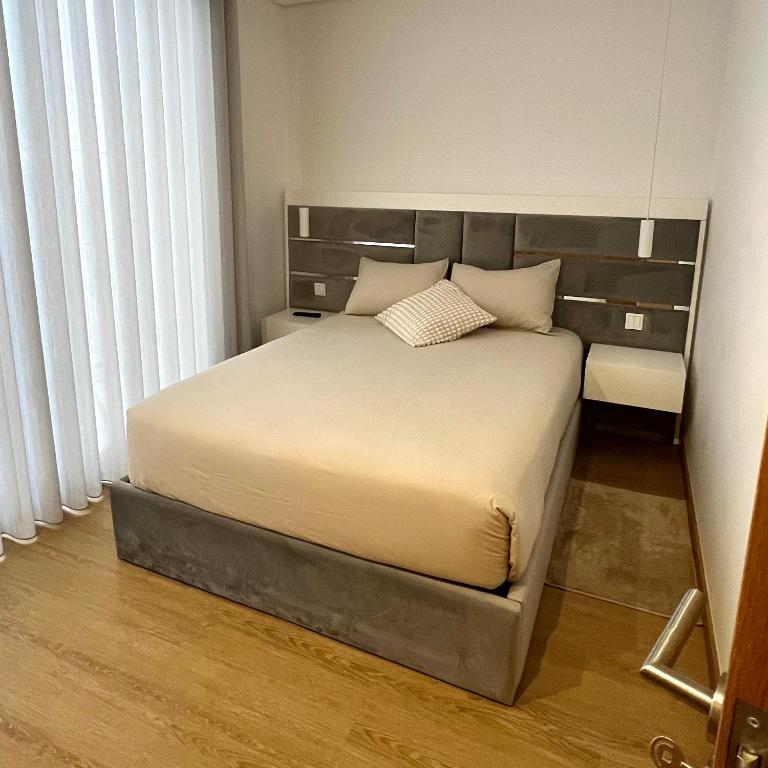 波尔图Coruja’s House AL OPO的一间卧室配有一张大床和床头板