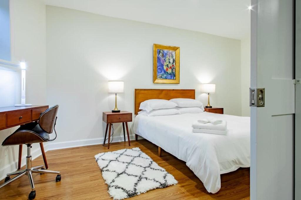 华盛顿A Classy Corner of DC Minutes walk to Dupont Circle的卧室配有一张白色的床、一张桌子和一把椅子