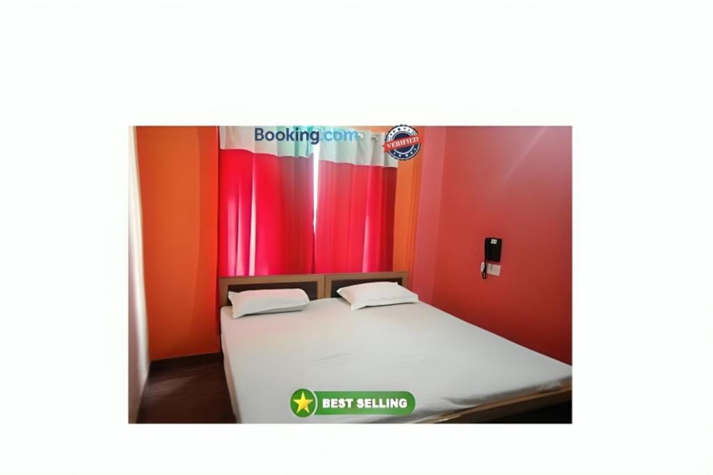 瓦拉纳西Hotel Kashi Inn Varanasi By GRG的红色墙壁的房间里一张床位