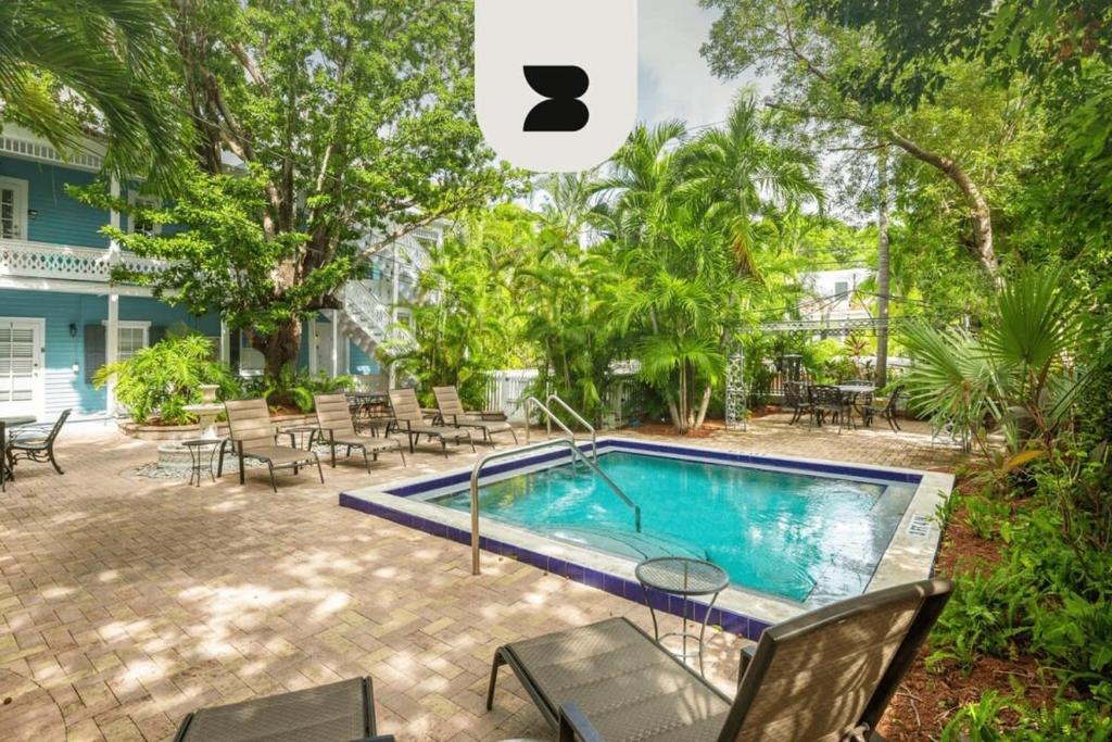 基韦斯特Sky Loft in Key West by Brightwild的庭院内的游泳池,配有桌椅