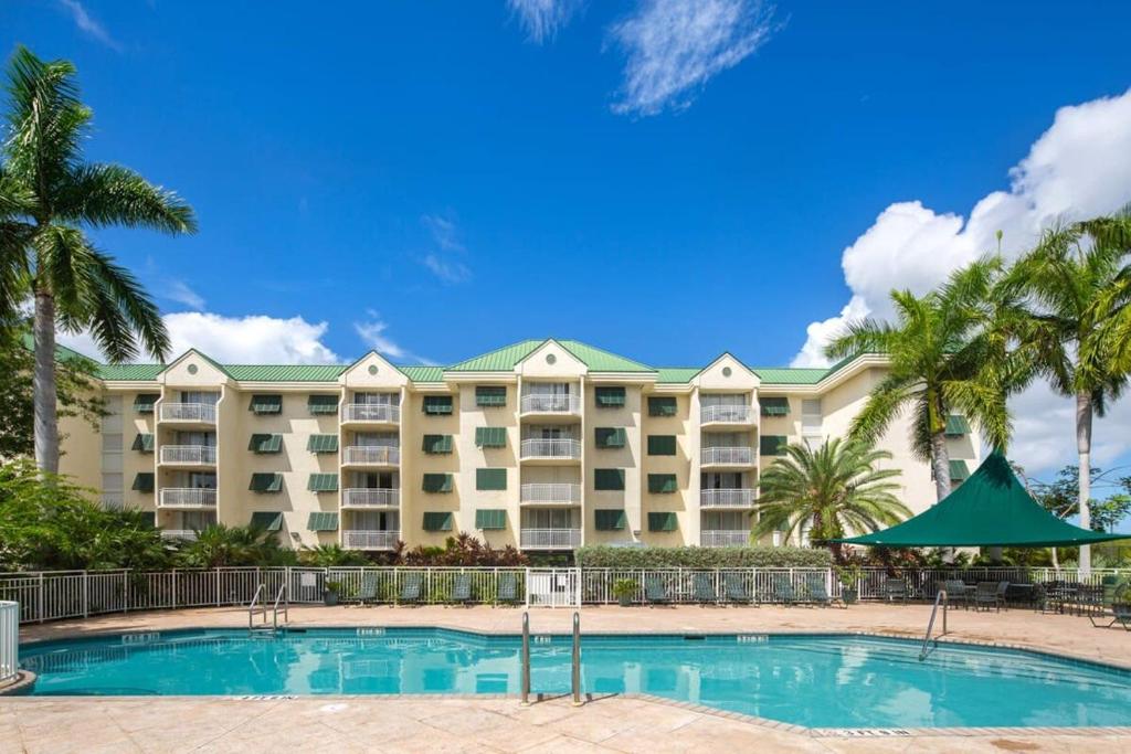 基韦斯特The Tortuga by Brightwild-Pool, Parking & Pets!的一座大型酒店,设有游泳池和棕榈树