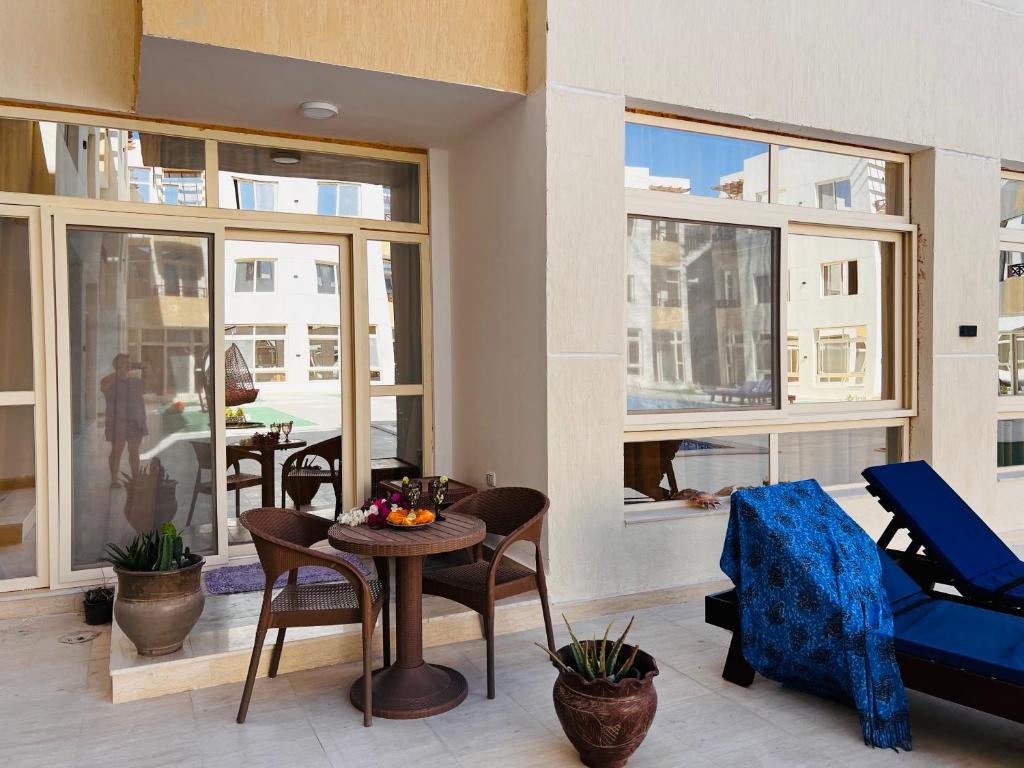 加利布港Port Ghalib Apartments的客厅配有桌椅和窗户。