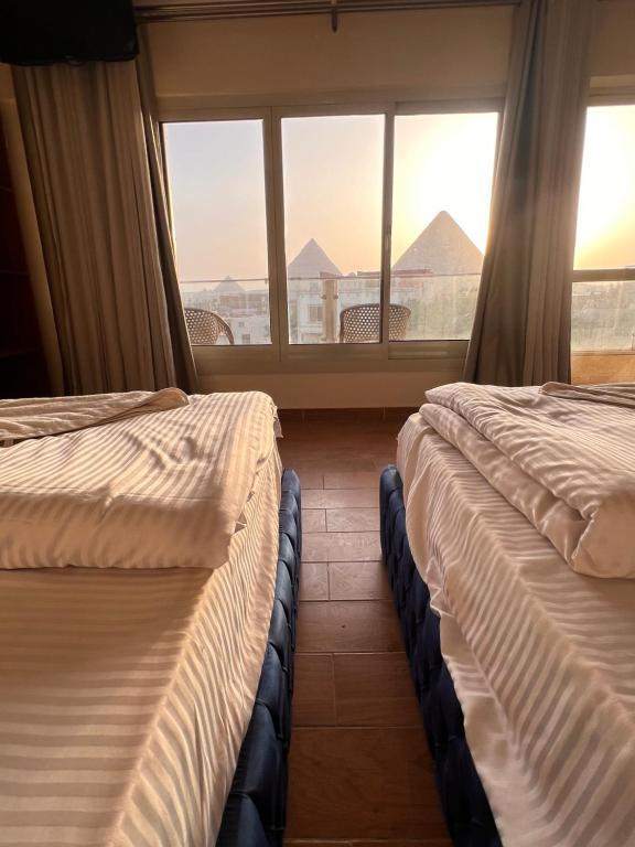 开罗Sphinx and Pyramids INN的两张床位于带窗户的房间内
